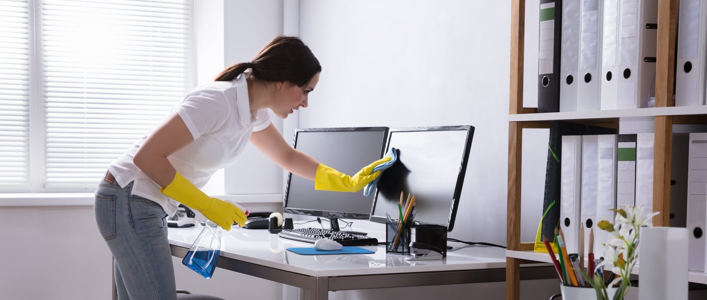 Woman Cleaning Computer In Office